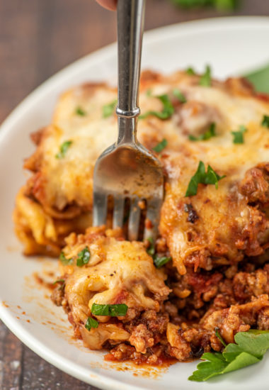 close-up photo of a fork cutting off a bite of lasagna