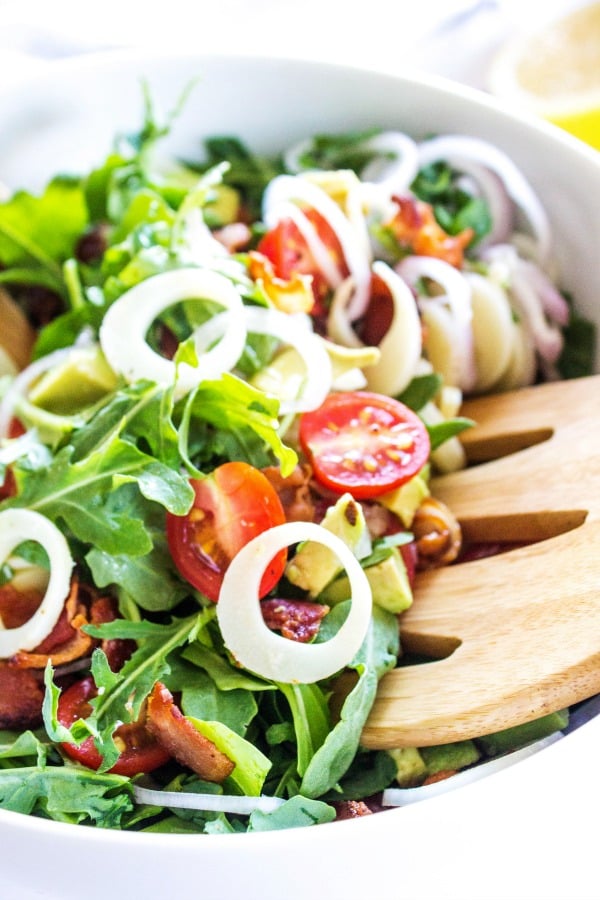 arugula and hearts of palm salad white bowl wooden salad spoon