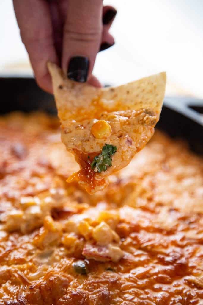 Grab a bag of chips and dig in. This Corn Queso dip is insanely cheesy, creamy & delicious. It will become your new favorite game day cheese dip. corn queso dip with chip