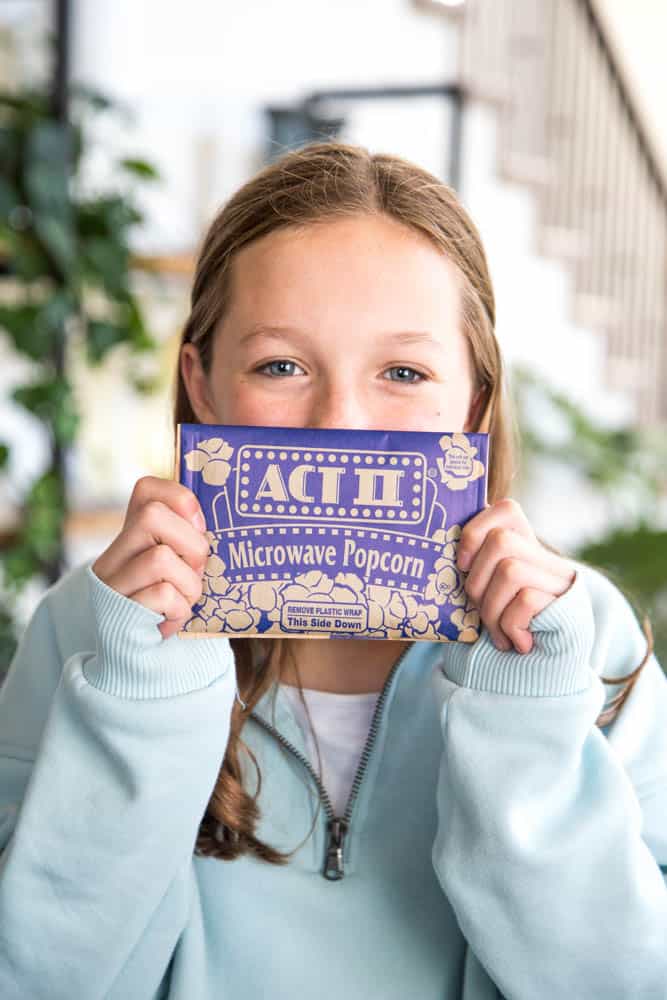 Act II popcorn with teenage girl smiling